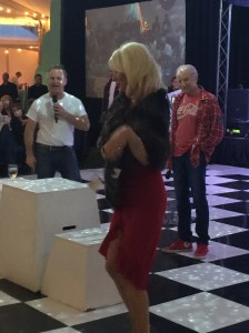 Kari Wells modeling Dennis Basso sable/mink stole for auction looked on by party host, Lenny 'Boogie' Weinglass. 